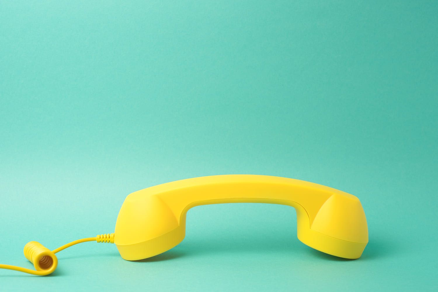 yellow telephone receiver turquoise background 1 1